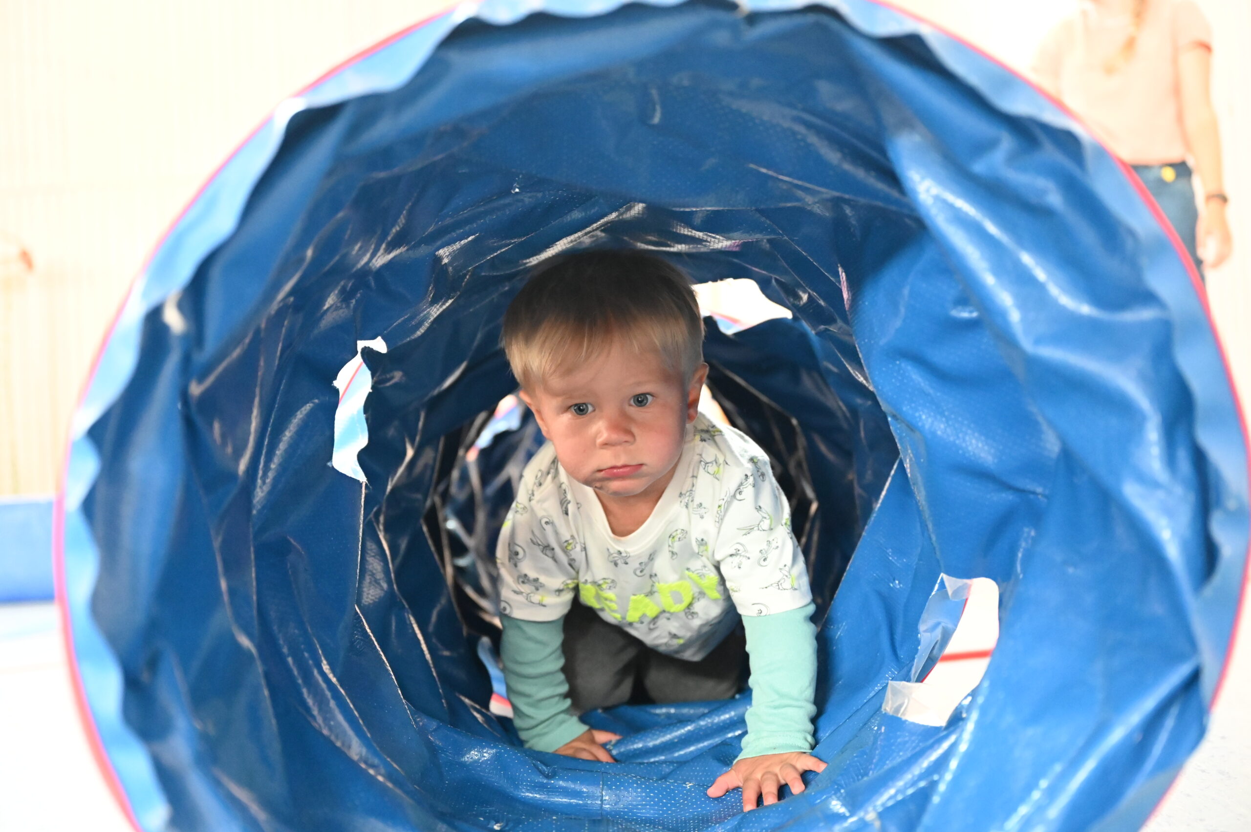 Junge in einem Kriechtunnel bei Bewegung und Asthmatherapie