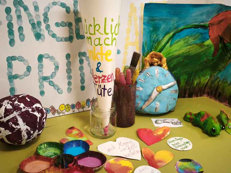 Im Bild sind alle Bestandteile einer Glücklichmachtüte für jüngere Kinder. Kleine Herzen oder Kreise werden bunt mit betropft. Auf der Rückseite steht das Ereignis, was glücklich macht. Diese können dann in die Tüte geworfen werden.